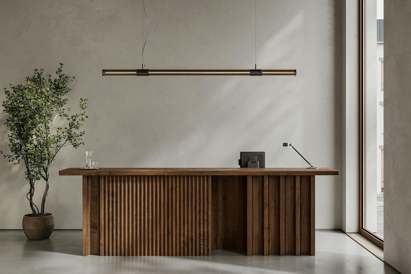 Office reception desk against a grey wall, with a tree and window light