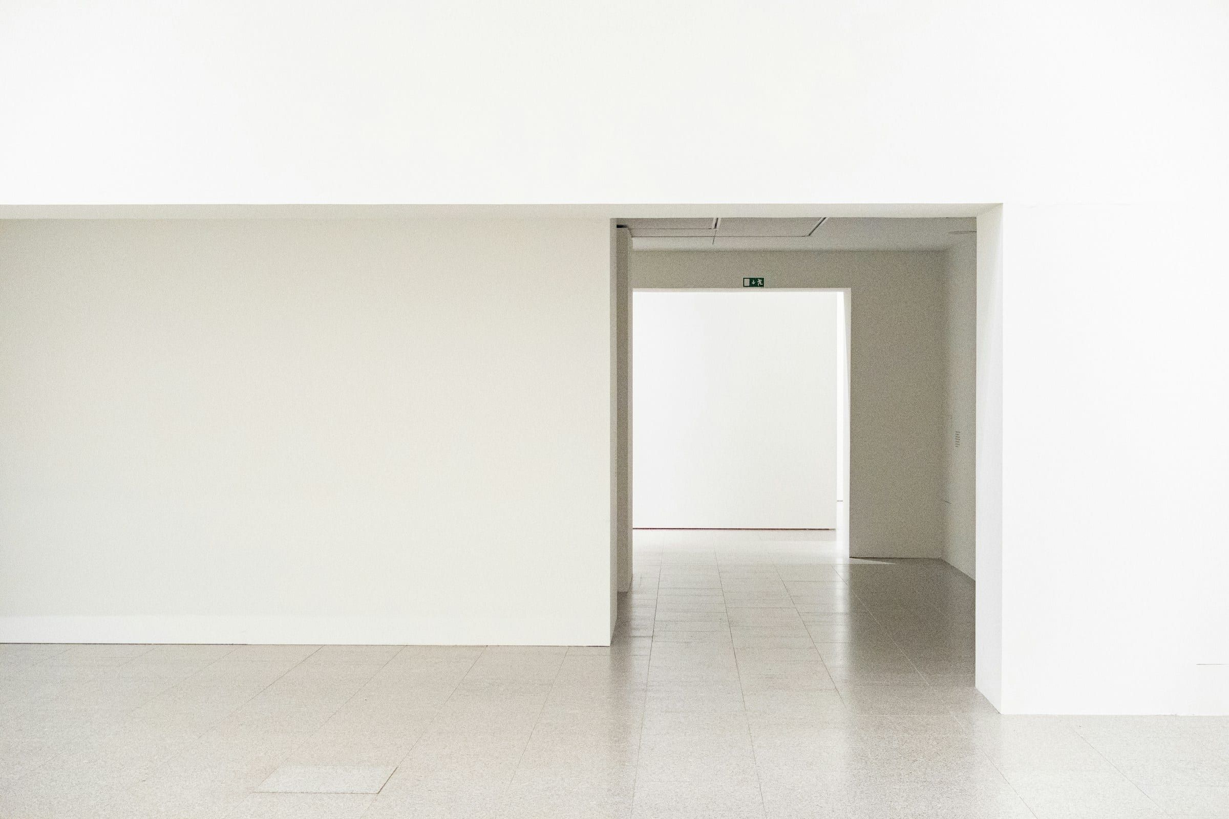 Empty freshly painted white room with a white door